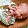 baby, newborn, blanket, infant, sleeping, soft_texture, cushion, closeup, wrapped, peaceful, cute, child, skin, head, hand, indoors, portrait, resting, cozy, serene