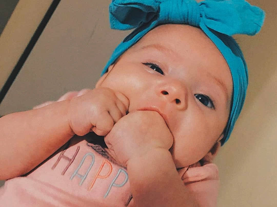 Elianna is registered to the contest to win money with this photo: baby, baby_toddler_clothing, blue, cap, cheek, eyebrow, eyelash, face, finger, gesture, happy, hat, headgear, lip, mouth, nose, person, skin, smile, sun_hat