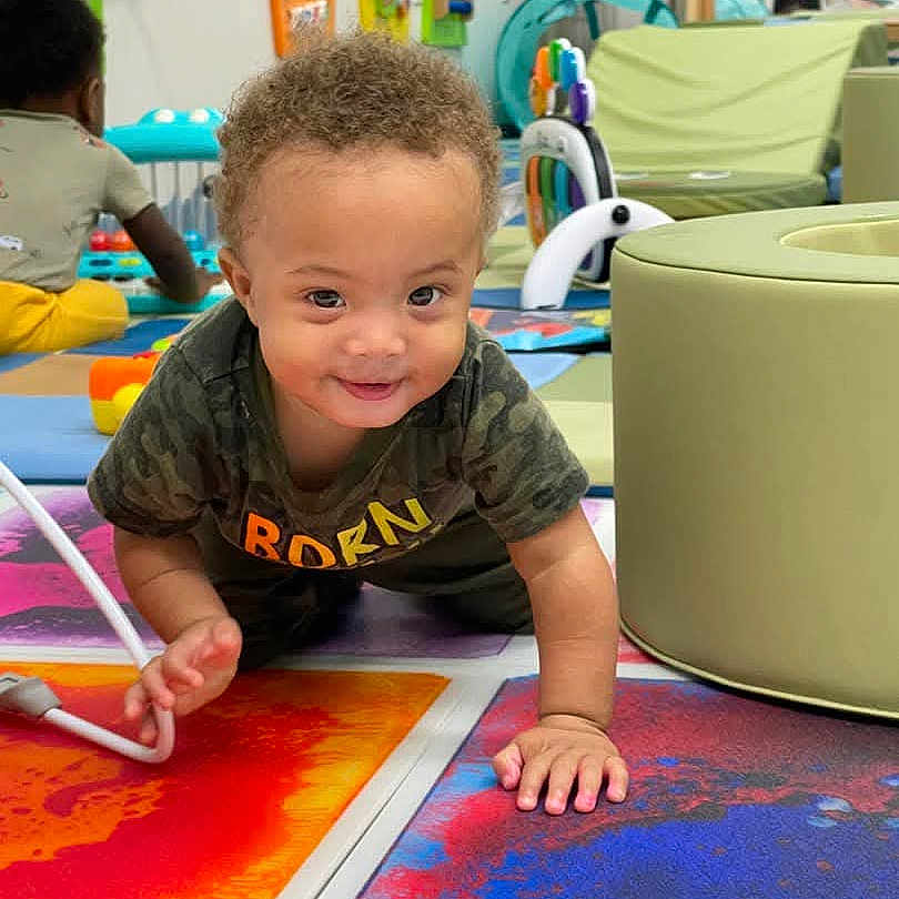 Daryl joined the competition — help win amazing prizes! baby, background, child, clothing, colorful_mats, crawling, curly_hair, cushion, development, floor, furniture, happy, indoor, other_child, person, play, playroom, smiling, toddler, toys