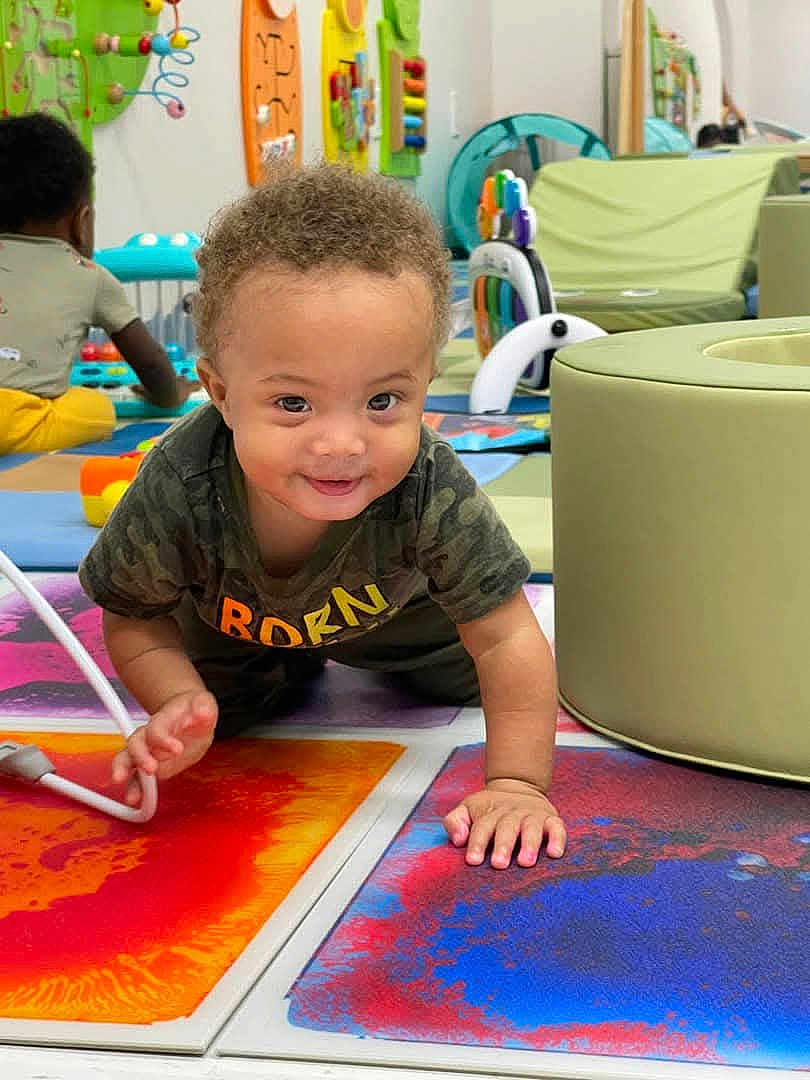 Daryl joined the competition — help win amazing prizes! toddler, child, crawling, playroom, toys, colorful_mats, indoor, baby, floor, curly_hair, smiling, person, furniture, play, background, other_child, clothing, happy, cushion, development