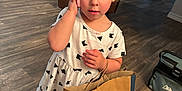 Rhiannon is registered to the contest to win money with this photo: child, girl, toddler, bow, purple_bow, dress, white_dress, shopping_bag, old_navy, phone, wood_floor, living_room, couch, shoes, indoor, person, handbag, flooring, home, furniture