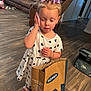 child, girl, toddler, bow, purple_bow, dress, white_dress, shopping_bag, old_navy, phone, wood_floor, living_room, couch, shoes, indoor, person, handbag, flooring, home, furniture