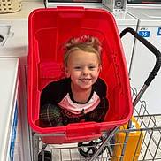 Rhiannon joined the competition — help win amazing prizes! child, smiling, laundromat, washing_machine, laundry_cart, red_cart, toddler, plaid_pants, black_and_white_shirt, floor, metal_cart, yellow_container, indoor, happy, person, toy_cart, hair, face, clothing, laundry_basket