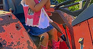 Malia joined the competition — help win amazing prizes! child, girl, cowboy_hat, pink_vest, denim_skirt, cowboy_boots, tractor, rusty, outdoor, sunlight, greenery, clapping, smiling, seat, farm, vehicle, cute, happy, nature, portrait