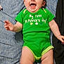 baby, child, infant, onesie, green_clothing, st_patrick, smiling, laughing, lying_down, blue_sheet, bed, chubby_legs, hands, face, hair, portrait, indoor, cute, happy, clothing