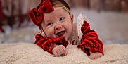 Eve is registered to the contest to win money with this photo: baby, blanket, cheerful, child, christmas, cozy, cute, face, happy, headband, holiday, indoor, infant, portrait, red_bow, red_clothing, smiling, soft_texture, toddler, young