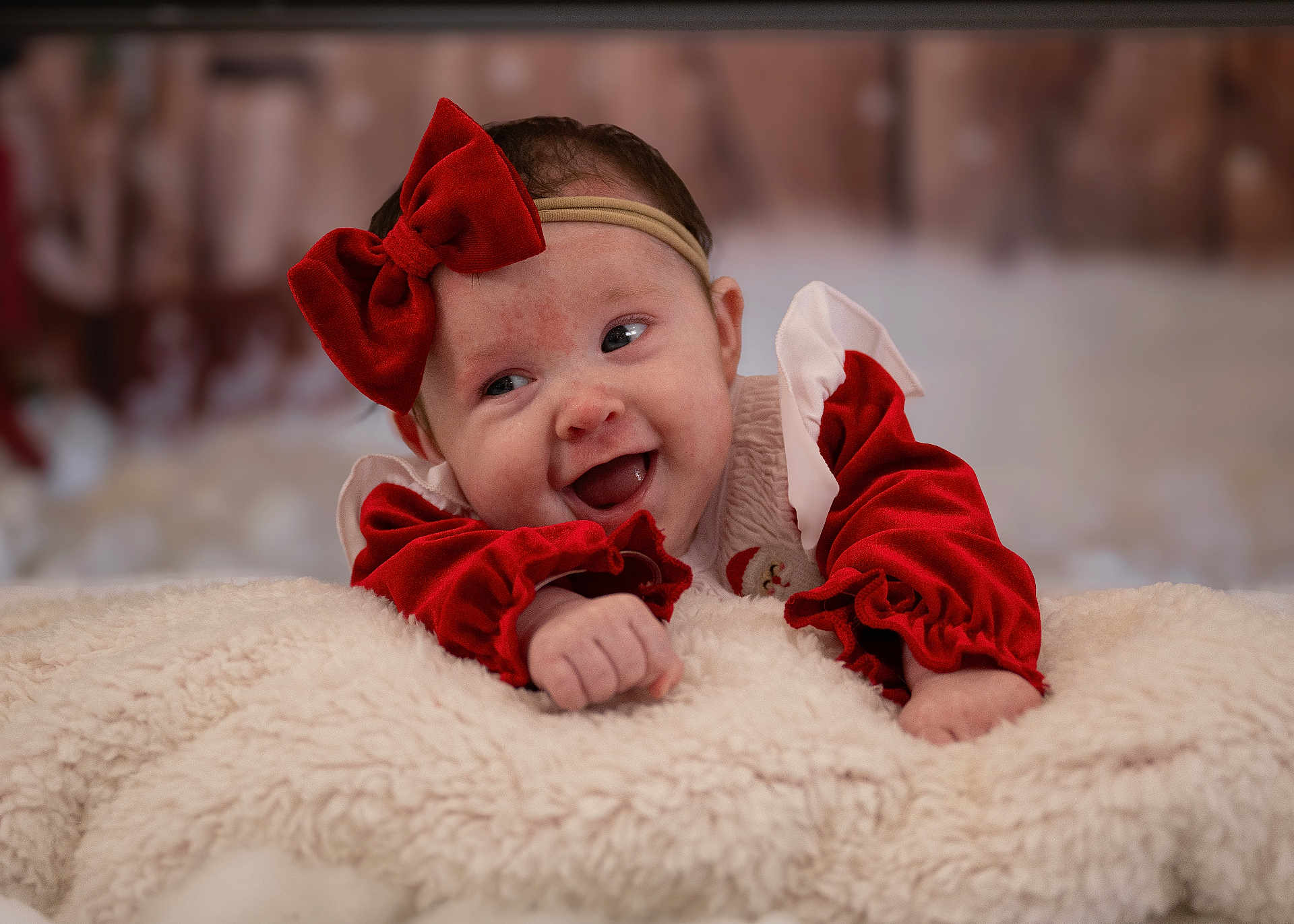 Eve is registered to the contest to win money with this photo: baby, infant, smiling, red_bow, red_clothing, headband, blanket, soft_texture, happy, cute, portrait, indoor, face, cheerful, holiday, christmas, cozy, child, young, toddler