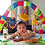 Avyaan joined the competition — help win amazing prizes! baby, child, play_mat, toy_arch, colorful, indoor, floor, curtains, sofa, couch, face, hand, onesie, toddler, furniture, plastic_toys, floor_mat, head, expression, home