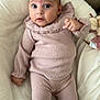 baby, infant, pink_clothing, knitwear, socks, lace, cushion, soft_fabric, indoor, person, face, eyes, hand, legs, head, portrait, lying_down, comfortable, cute, child