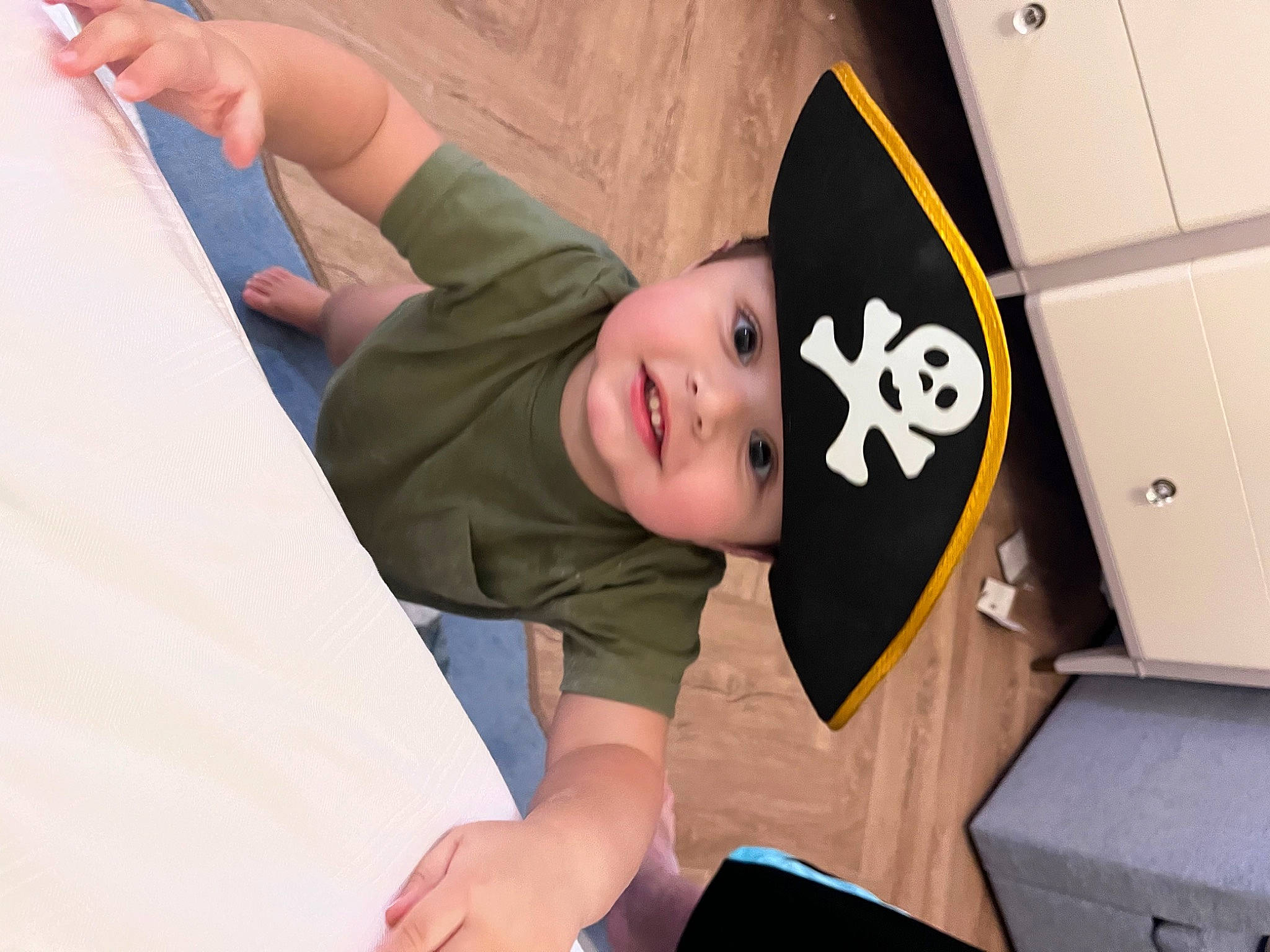 Frankie is registered to the contest to win money with this photo: baseball_cap, box, cap, child, elbow, event, fun, happy, hat, headwear, person, room, shipping_box, sitting, t_shirt, toddler