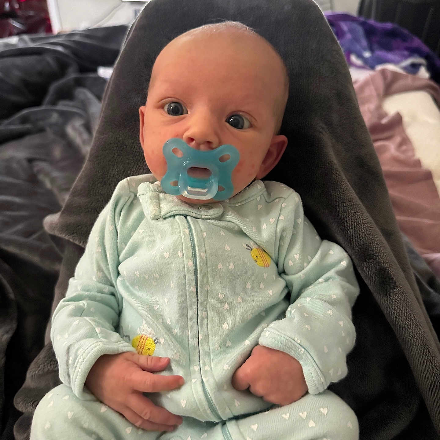Rosie is registered to the contest to win money with this photo: baby, bed, blanket, bodypart, clothing, coat, couch, cushion, face, furniture, head, homedecor, indoors, jacket, pajamas, pants, person, photography, portrait, sitting