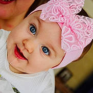 Romane a rejoint le concours — aidez-le/la à gagner de superbes lots ! baby, baby_girl, blue_eyes, child, closeup, cute, drool, face, happy, headband, headwear, indoor, infant, person, pink_bow, portrait, smile, white_clothing, woman_partial, young_child