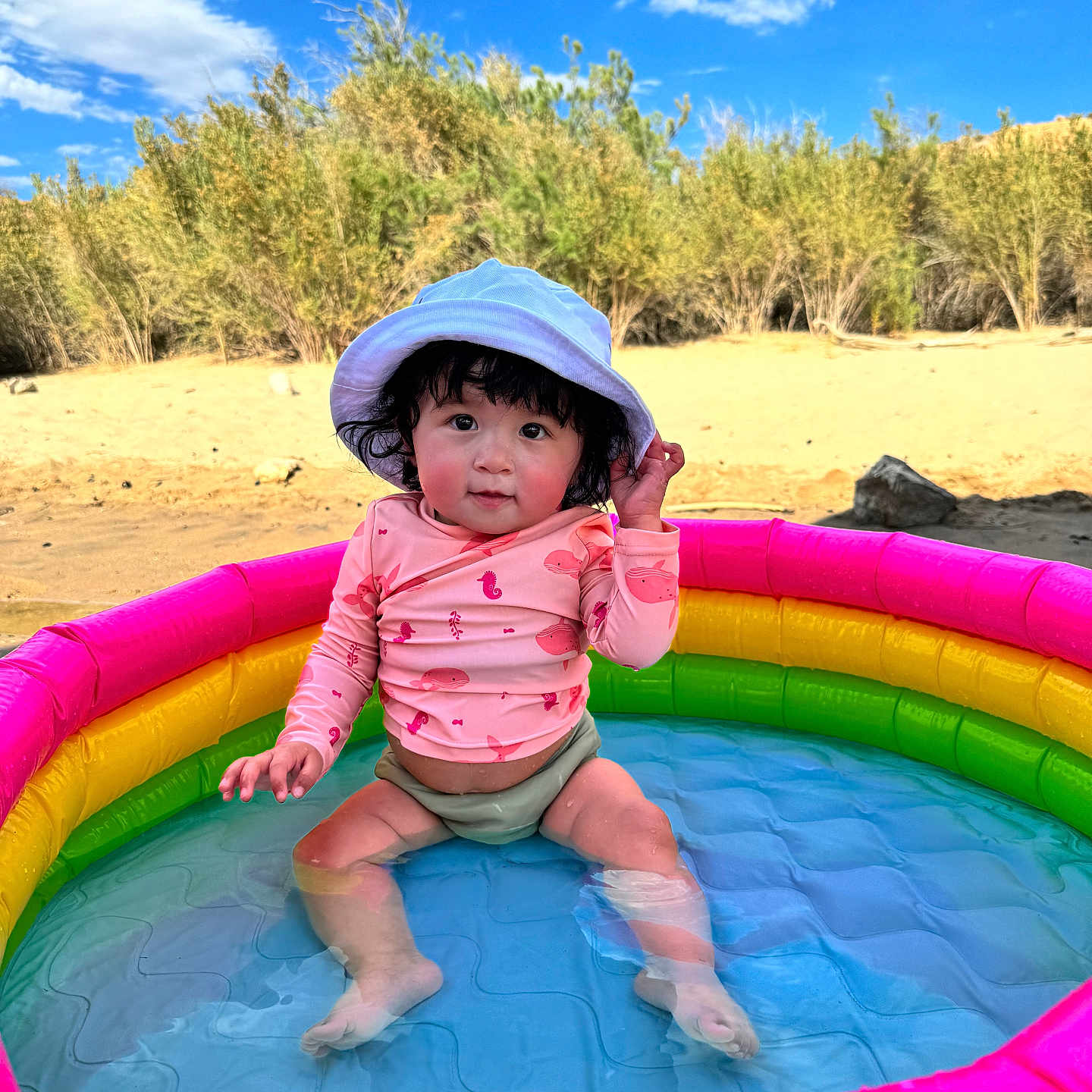 Lailah is registered to the contest to win money with this photo: baby, clothing, face, grass, hat, head, inflatable, outdoorplayarea, outdoors, person, photography, playarea, pool, portrait, slide, summer, sunhat, swimwear, toy, water