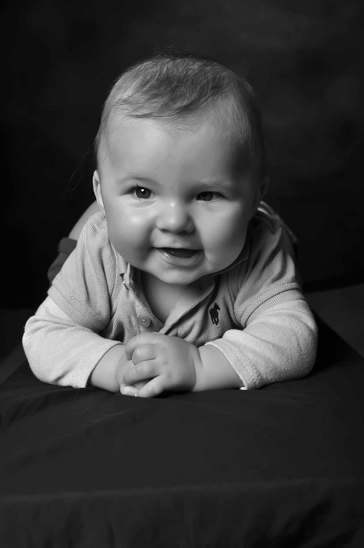Pierre participe au concours pour gagner de l'argent avec cette photo : baby, infant, smiling, face, portrait, black_and_white, cute, toddler, child, hands, clothing, long_sleeve, lying_down, cheeks, expression, head, eyes, happy, studio, young