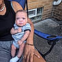 Aspen And Denver is registered to the contest to win money with this photo: baby, child, adult, person, outdoor, brick_wall, concrete, chair, blue_chair, clothing, sitting, medical_patch, bracelet, necklace, sock, shorts, hand, face, expression, skin