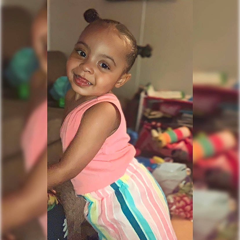 Nalani joined the competition — help win amazing prizes! baby, baby_toddler_clothing, cheek, child, fun, happy, joy, laugh, linens, magenta, person, photo_caption, portrait_photography, room, selfie, sitting, smile, t_shirt, toddler, visual_arts