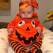Poppy joined the competition — help win amazing prizes! baby, child, costume, pumpkin, orange, headband, striped_leggings, sitting, indoor, cute, holiday, halloween, clothing, face, expression, soft_lighting, decor, infant, portrait, cozy