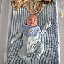 baby, crib, blanket, plush_toy, teddy_bear, giraffe, onesie, bib, infant, blue, soft_toy, sleeping_area, cute, child, portrait, lying_down, baby_clothes, nursery, cozy, resting