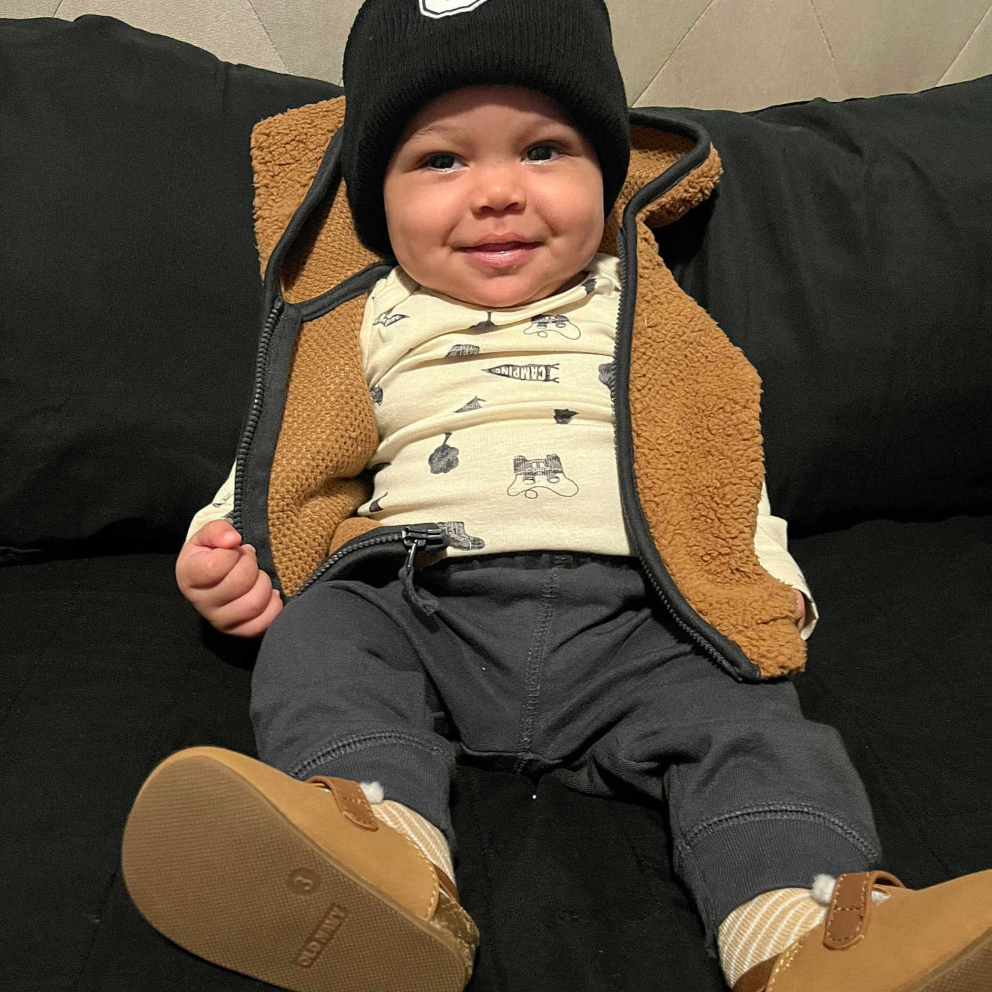 Jasonny joined the competition — help win amazing prizes! baby, beanie, black_couch, brown, child, clothing, cozy, cute, face, happy, indoor, infant, pants, portrait, seated, shirt, shoes, smiling, socks, vest