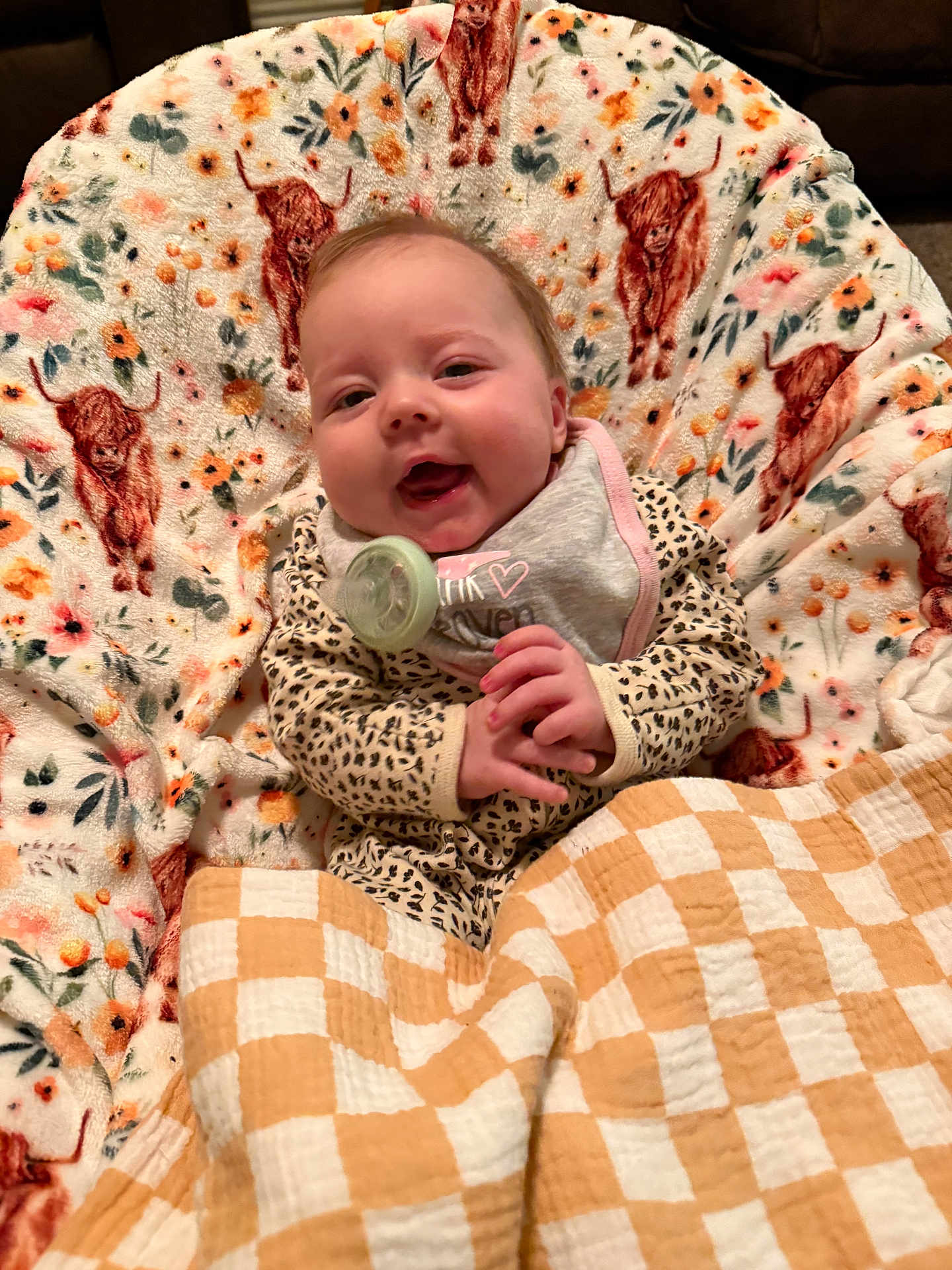 Jolee joined the competition — help win amazing prizes! baby, child, smile, blanket, pacifier, cozy, pattern, animal_print, cheerful, cute, infant, clothing, indoor, face, portrait, comfort, happy, sitting, plaid, fabric
