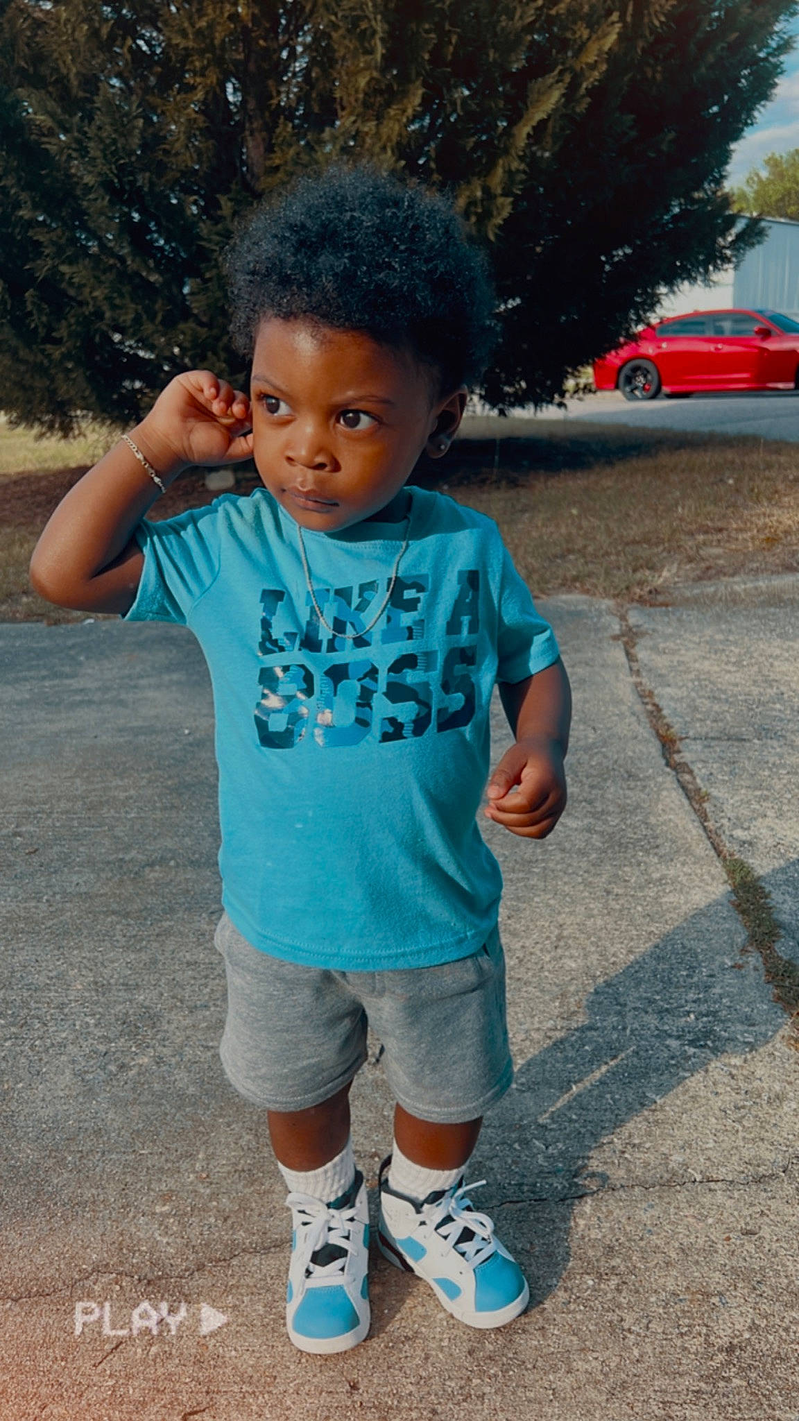 Khamari is registered to the contest to win money with this photo: car, child, cool, electric_blue, eye, face, hair, hairstyle, happy, head, leisure, person, pink, shorts, sleeve, sportswear, street_fashion, t_shirt, tire, toddler