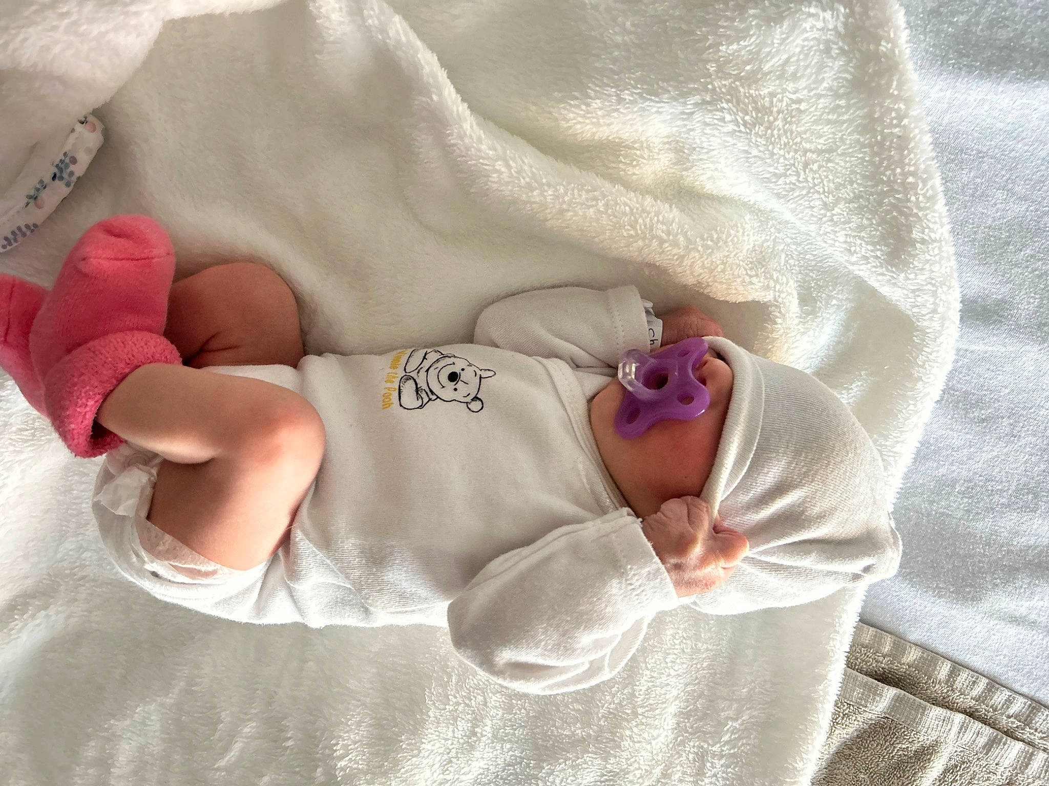 Aria a rejoint le concours — aidez-le/la à gagner de superbes lots ! baby, baby_products, baby_sleeping, baby_toddler_clothing, bed_sheet, bedding, comfort, diaper, dress, fashion_accessory, hand, headgear, human_leg, linens, pattern, peach, person, pink, room, sleeve