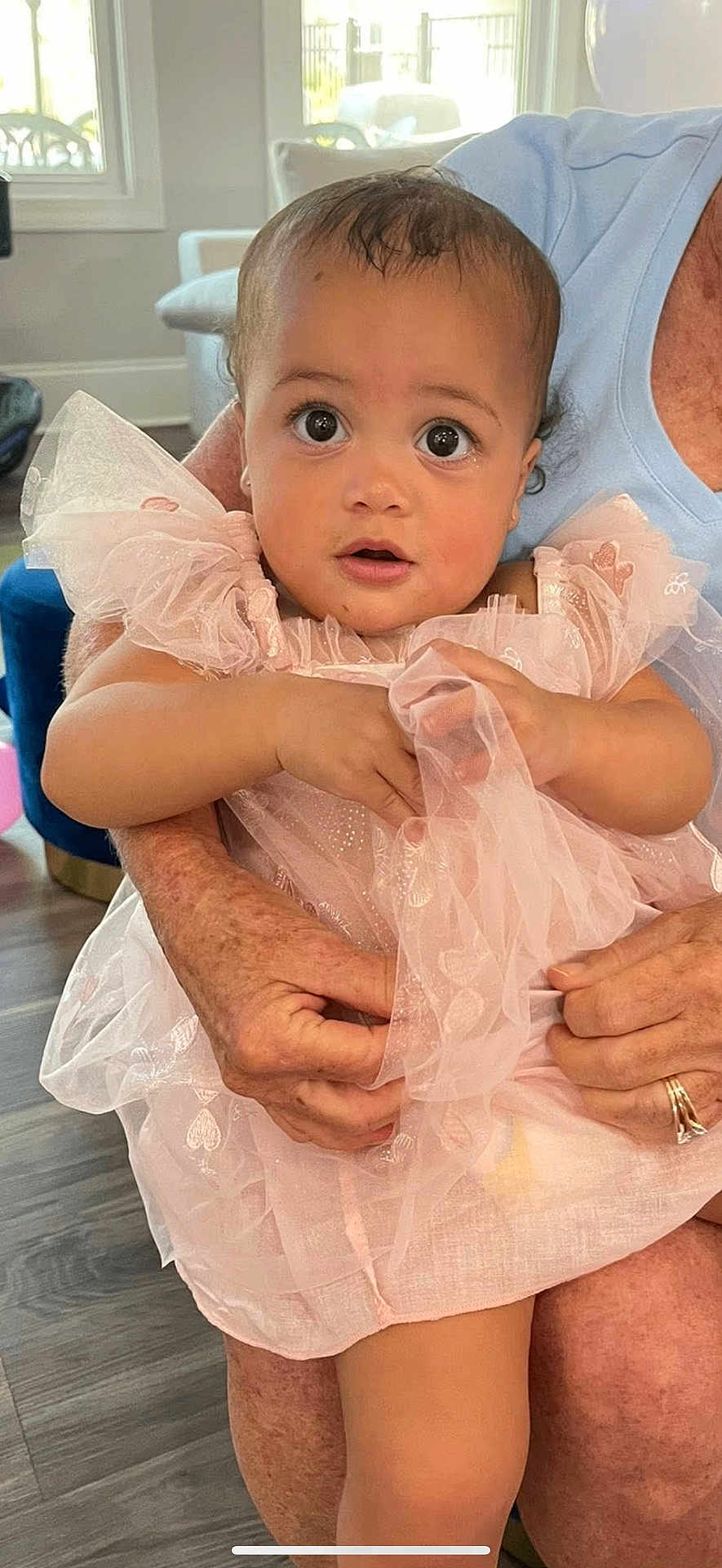Maeve joined the competition — help win amazing prizes! baby, child, person, dress, pink, hands, indoor, floor, window, furniture, skin, face, eyes, expression, holding, sitting, adult, ring, natural_light, curtain