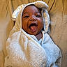 Ryaire joined the competition — help win amazing prizes! baby, towel, hood, smile, happy, infant, cute, face, mouth_open, wrapped, bed, fabric, texture, cozy, child, skin, person, indoors, soft, warm_lighting
