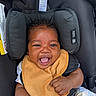 Ryaire is registered to the contest to win money with this photo: baby, infant, car_seat, smile, happy, child, bib, clothing, seatbelt, curly_hair, skin, portrait, cute, baby_boy, sitting, indoors, head_support, safety, hand, closeup
