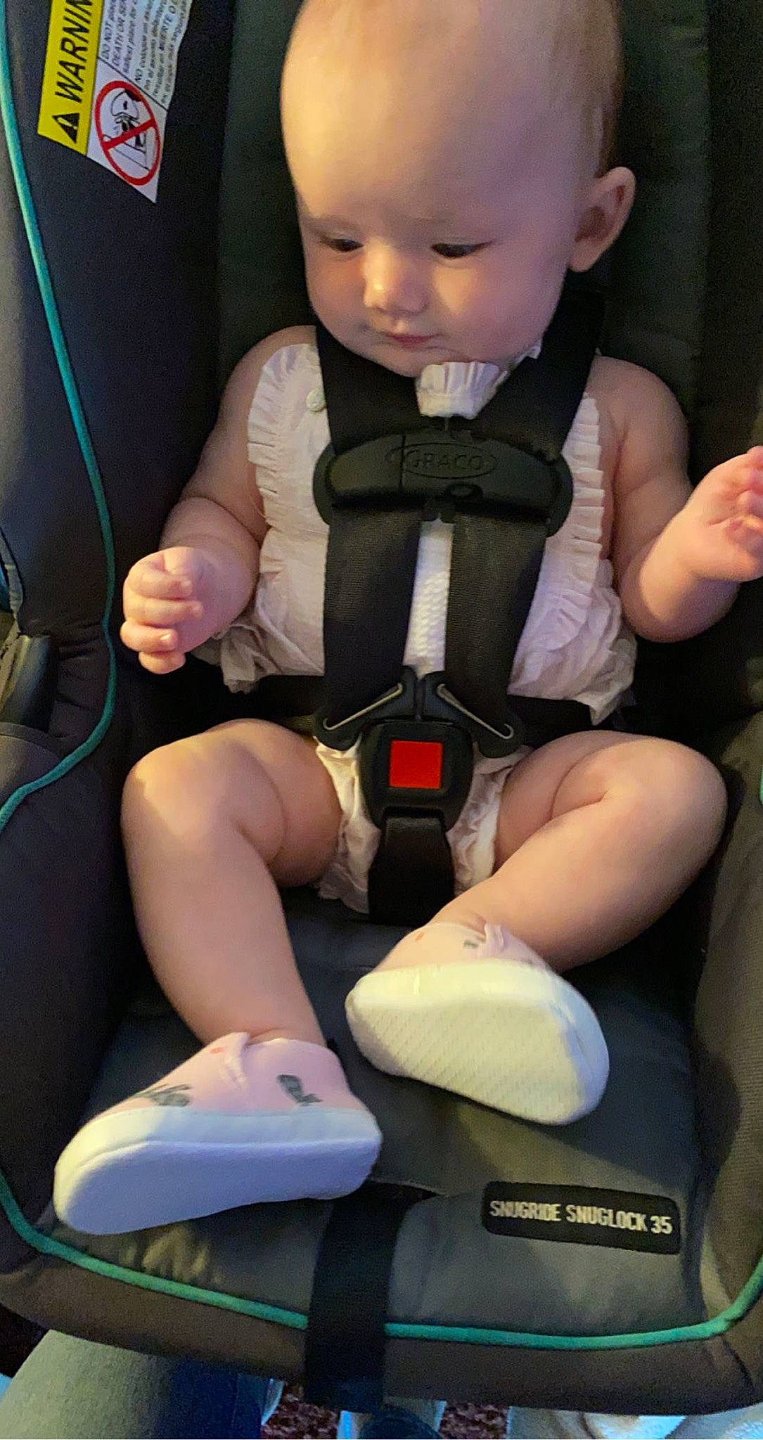 Braxtyn is registered to the contest to win money with this photo: arm, baby, baby_toddler_clothing, blue, cheek, comfort, doll, finger, hand, joint, knee, lap, leg, person, seat_belt, skin, thigh, toddler, toy, white