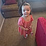 Azalea is registered to the contest to win money with this photo: toddler, child, girl, dress, pink, barefoot, carpet, living_room, sofa, cushion, hair, ponytail, holding, toy, indoor, person, cute, young, small, standing