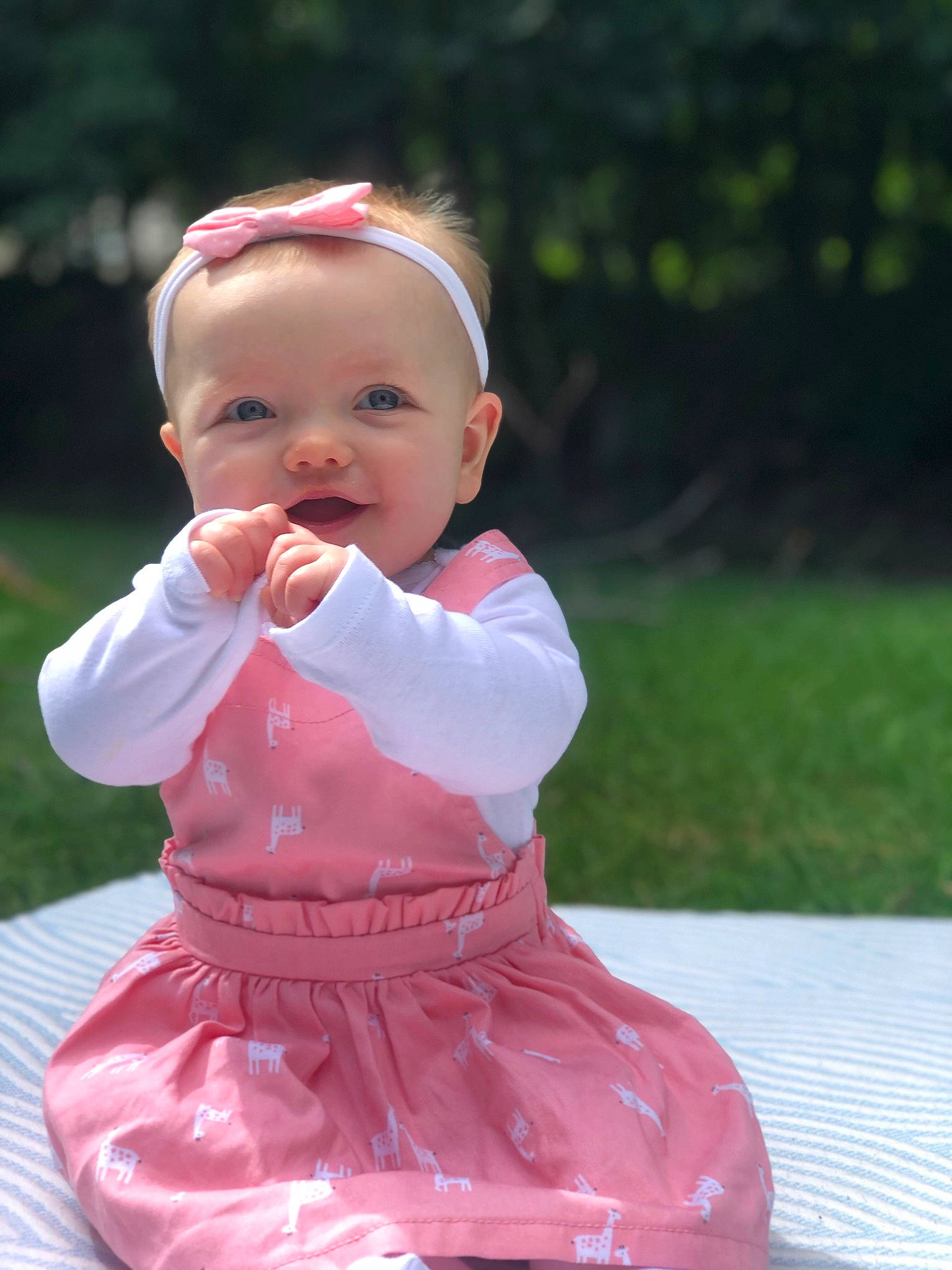 Lucia is registered to the contest to win money with this photo: baby, baby_toddler_clothing, cheek, chin, dress, face, fun, grass, hair, happy, head, kneeling, leisure, lip, people_in_nature, person, pink, skin, sleeve, smile