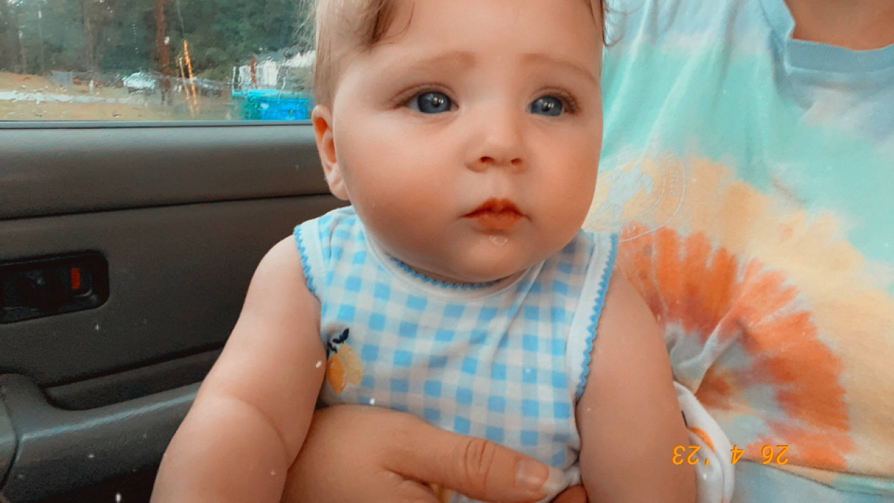 Emilee is registered to the contest to win money with this photo: baby, baby_toddler_clothing, cheek, chin, dress, eye, eyelash, face, finger, hand, happy, head, iris, lip, mouth, nose, person, skin, toddler, vehicle