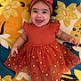 baby, child, smiling, dress, headband, bow, orange, gold, polka_dots, blanket, floral, happy, cute, infant, portrait, lying_down, celebration, fabric, pattern, toddler