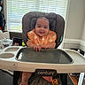 baby, high_chair, smile, bib, orange, elephant_pattern, indoor, window, blinds, table, foot, baby_seat, happy, child, person, furniture, room, daylight, home, cute