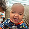 Cason joined the competition — help win amazing prizes! baby, child, smiling, happy, pajamas, space_theme, couch, indoor, curly_hair, window_blinds, light, portrait, close_up, person, infant, cozy, family, sitting, cute, fun