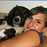 Bella is registered to the contest to win money with this photo: affection, animal, black_and_white_dog, casual, closeup, comfortable, companion, couch, dog, friendship, happy, home, human, indoor, pet, portrait, relaxed, smiling, snuggling, woman