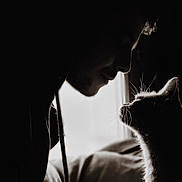 Junie participe au concours pour gagner de l'argent avec cette photo : person, cat, silhouette, black_and_white, whiskers, profile, indoor, bed, window, soft_light, close_up, intimate, animal, human, face_to_face, pet, shadow, contrast, quiet, moment