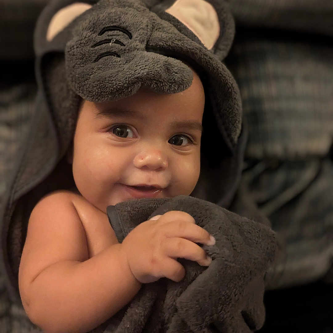 Cameron joined the competition — help win amazing prizes! baby, blanket, bodypart, clothing, couch, face, finger, furniture, hand, happy, hat, head, hood, hoodie, knitwear, person, photography, portrait, smile, towel