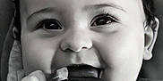 Tyana participe au concours pour gagner de l'argent avec cette photo : adorable, baby, black_and_white, chewing, child, close_up, curly_hair, cute, expression, fabric, face, hands, happy, indoors, infant, pacifier, portrait, smiling, soft_light, young