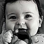 baby, infant, black_and_white, close_up, chewing, fabric, hands, pacifier, cute, child, portrait, smiling, young, face, curly_hair, expression, soft_light, indoors, adorable, happy