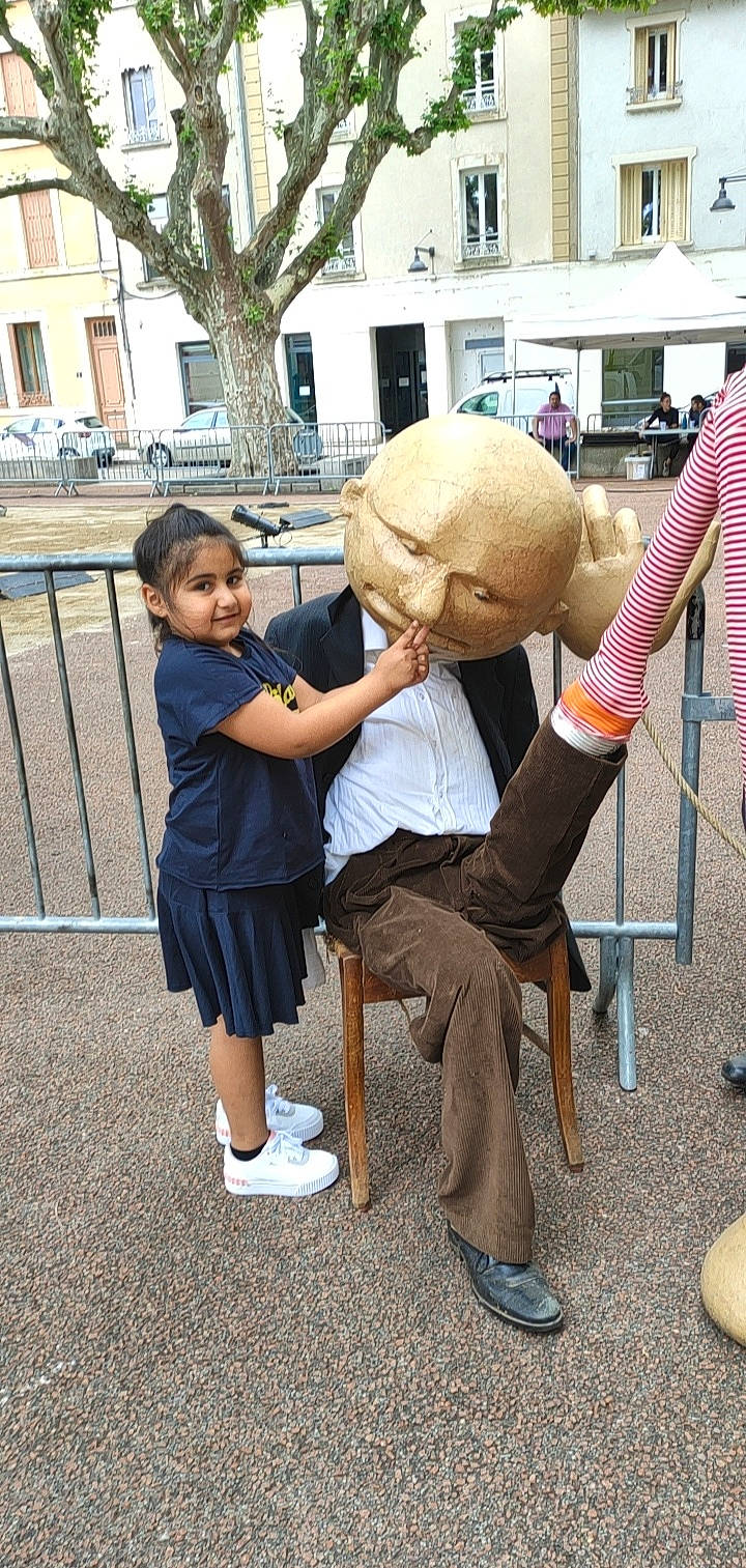 Melyna a rejoint le concours — aidez-le/la à gagner de superbes lots ! art, child, event, eyewear, fun, gesture, hat, leg, leisure, luggage_and_bags, people, person, public_space, recreation, sandal, sculpture, shoe, shorts, sneakers, tree