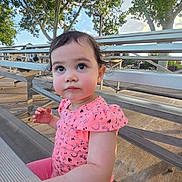 Athena joined the competition — help win amazing prizes! toddler, child, outdoor, bench, bleachers, pink_clothing, tree, daylight, curious, person, young_child, sitting, playful, sunlight, nature, park, casual, portrait, cute, face