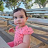 toddler, child, outdoor, bench, bleachers, pink_clothing, tree, daylight, curious, person, young_child, sitting, playful, sunlight, nature, park, casual, portrait, cute, face