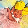 baby, newborn, yellow_bow, pink_tutu, pastel_blanket, infant, cute, smiling, clothing, headwear, soft_texture, lying_down, child, adorable, portrait, small_hands, cozy, colorful, happy, baby_girl