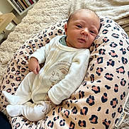 Roméo participe au concours pour gagner de l'argent avec cette photo : baby, newborn, infant, onesie, leopard_print, baby_pillow, giraffe_print, blanket, indoor, soft_texture, shelf, books, cozy, cute, child, person, portrait, relaxing, home, comfort