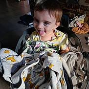 Eden a rejoint le concours — aidez-le/la à gagner de superbes lots ! toddler, child, laundry_basket, clothing, indoor, playful, tongue_out, happy, face, person, fabric, textile, household, floor, brick_wall, casual, cute, smiling, baby, soft_light