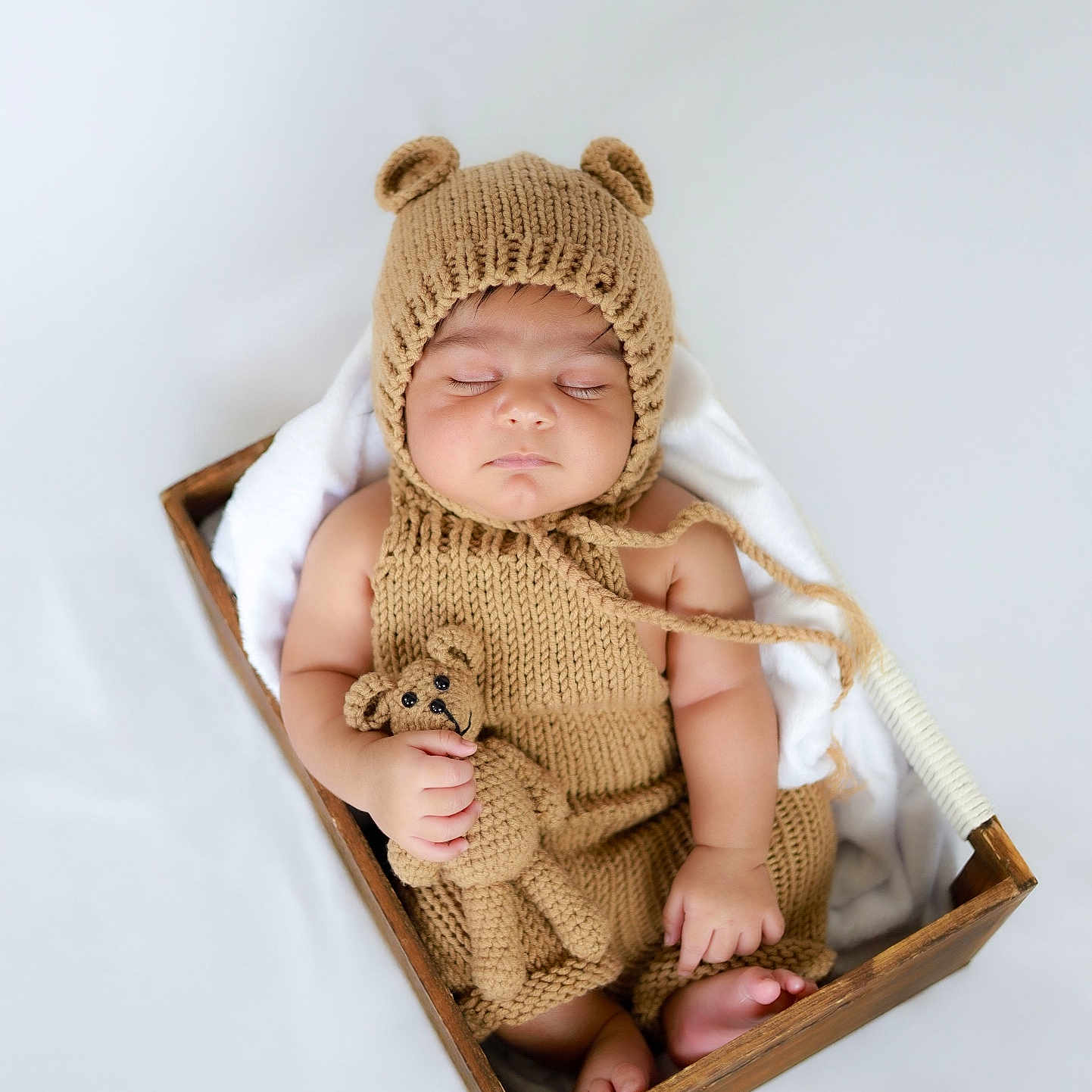Divansh Prasad is registered to the contest to win money with this photo: baby, bear_hat, blanket, child, cozy, cute, foot, hand, hat, indoors, infant, knitted_clothing, knitwear, newborn, peaceful, portrait, sleeping, soft_toy, teddy_bear, wooden_box
