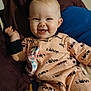 baby, smiling, onesie, love_print, pacifier_clip, toy, bed, pillow, indoor, child, happy, cute, infant, clothing, person, face, relaxing, cheerful, comfort, playful
