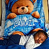 newborn, baby, sleeping, teddy_bear, stuffed_animal, blanket, bed, blue, star_pattern, cozy, portrait, indoors, nursery, infant, lying_down, peaceful, clothing, pajamas, plush_toy, nap